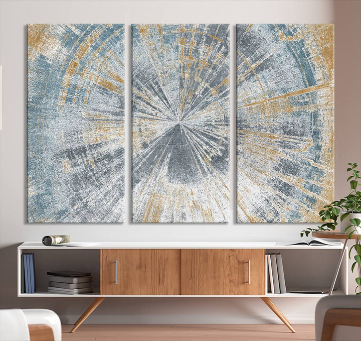 The Radiant Abstract Wood Rings Canvas Art, a modern triptych wall decor, enhances the contemporary style of the living room with its blue, white, and gold hues.