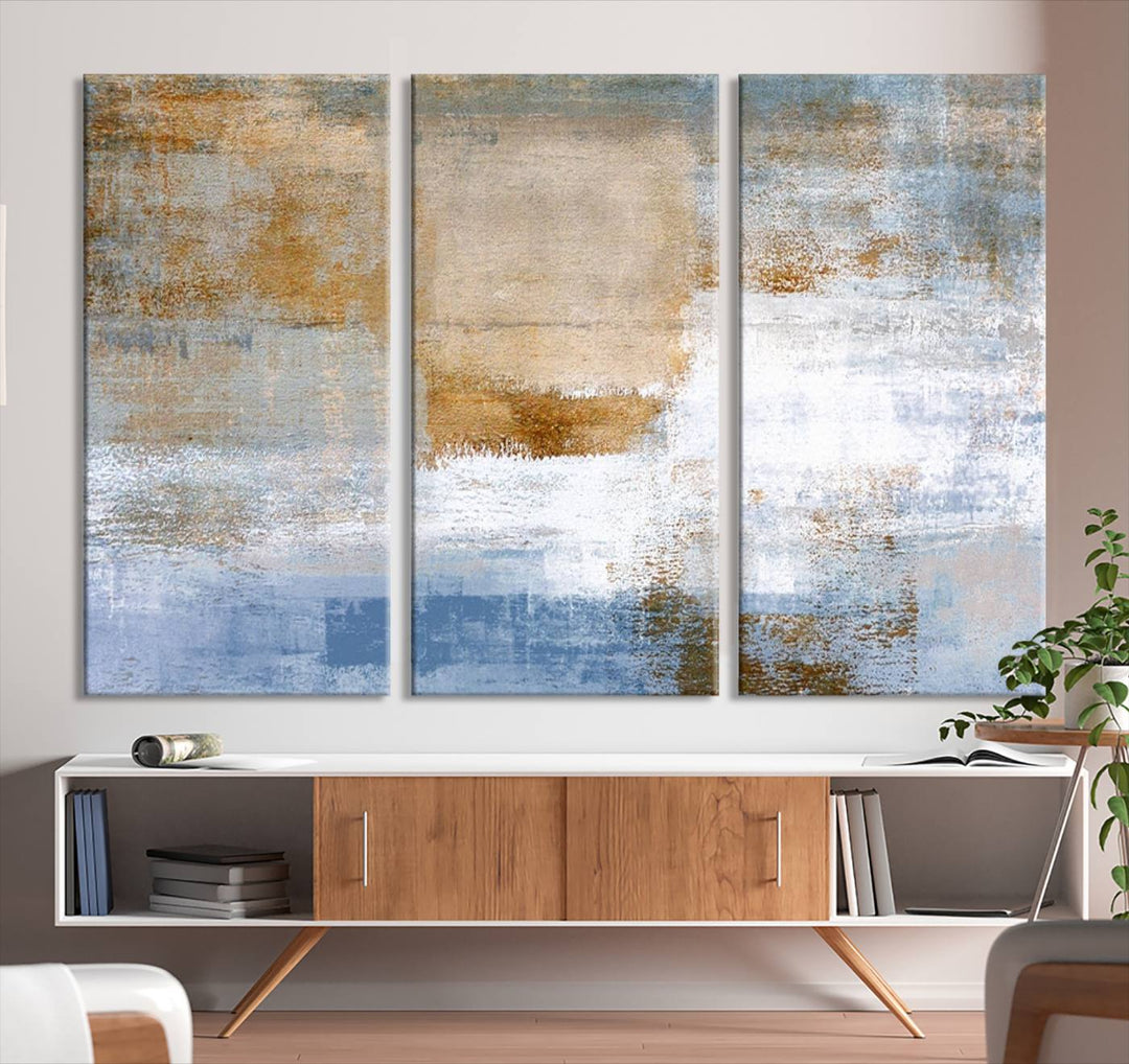 The Blue Multi Panel Abstract Wall Art Canvas Print, featuring an elegant blend of blue, beige, and brown tones, hangs gracefully on the wall, adding a contemporary touch to the space.