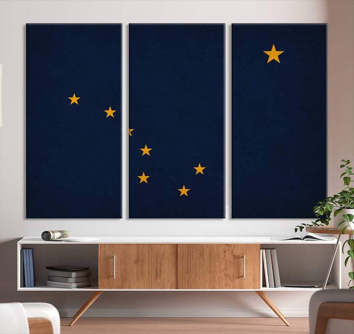 A contemporary living room featuring a triptych artwork of stars on a navy background, accentuated by the striking Alaska States Flag Wall Art Canvas Print.