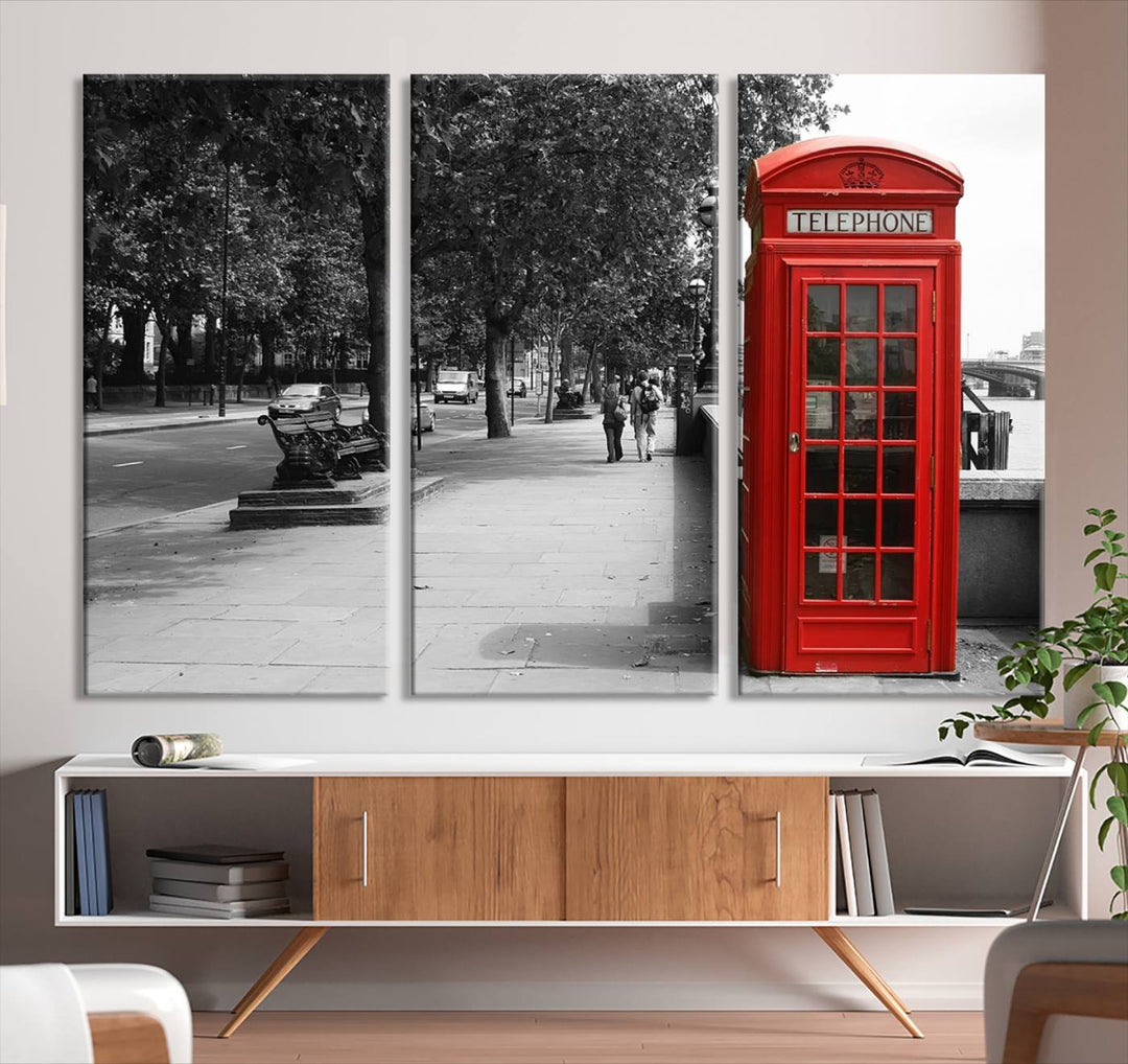 The London Phone Club Wall Art is a stunning piece that showcases a red telephone box set in a black and white street scene on museum-quality canvas. It is gallery wrapped with a UV-protective coating to preserve its vibrant charm.