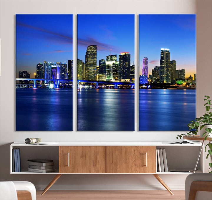 The modern living room showcases a striking Miami Blue Night Wall Art canvas print on the wall. The artwork is gallery wrapped on museum-quality canvas, ensuring durability and elegance.