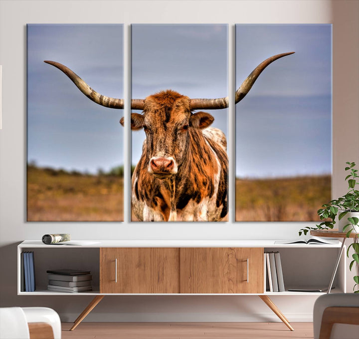 The Texas Longhorn Wall Art Print, a triptych canvas artwork depicting a longhorn bull in a field, features a gallery-quality finish.