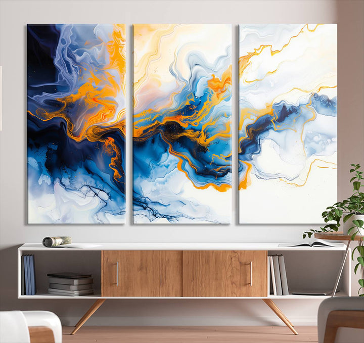 A stunning Fluid Alcohol Ink Wall Art with Gold Wall Art Canvas Print, featuring vibrant blue, orange, and white swirls, adorns the wall. This gallery-quality finish adds an exquisite touch to any living space.