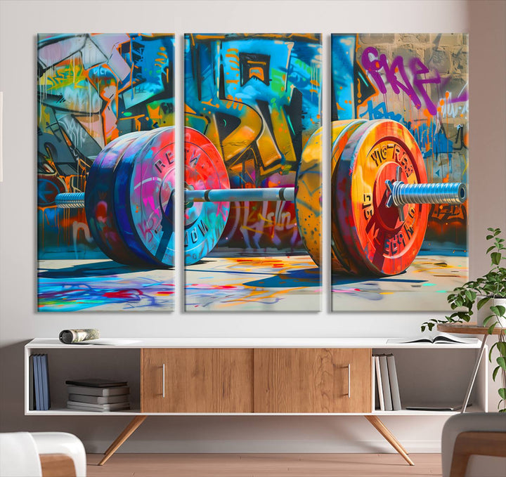 The Fitness Gym Barbell Graffiti Wall Art Canvas Print, a vibrant triptych featuring a barbell against a graffiti backdrop, elegantly hangs in the room. Crafted on premium canvas with a gallery-quality finish, this stunning piece of wall art effortlessly combines urban flair with sophisticated decor.