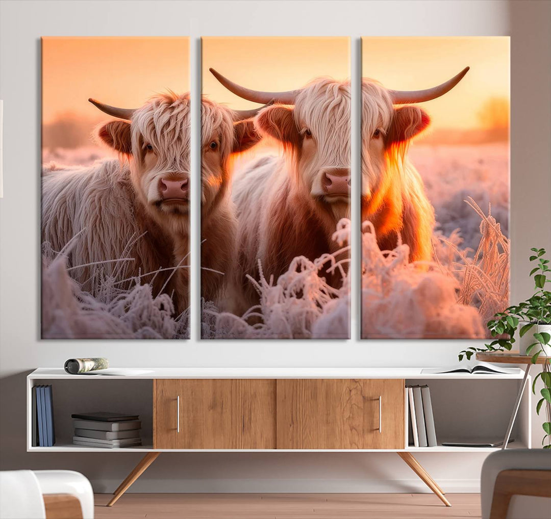 The "Highland Cows at Sunrise Wall Art Canvas Set" beautifully captures a serene and rustic farmhouse aesthetic, portraying two Highland cows in a frosty landscape at sunrise.