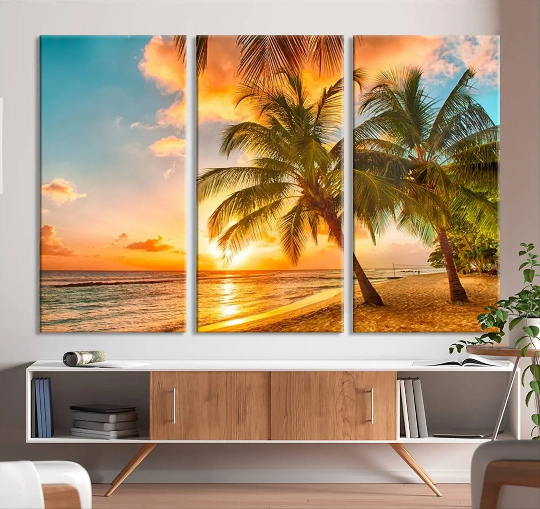 The Tropical Sunset Wall Art Print features a vibrant beach scene with palm trees and an ocean view highlighted by a golden sunset.