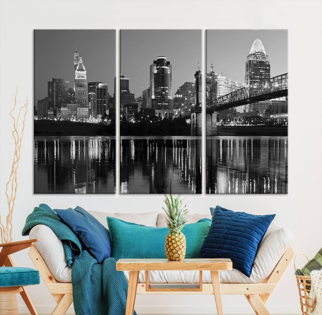 The wall showcases a ready-to-hang triptych of the Cincinnati City Lights Skyline in black and white, printed on museum-quality canvas.