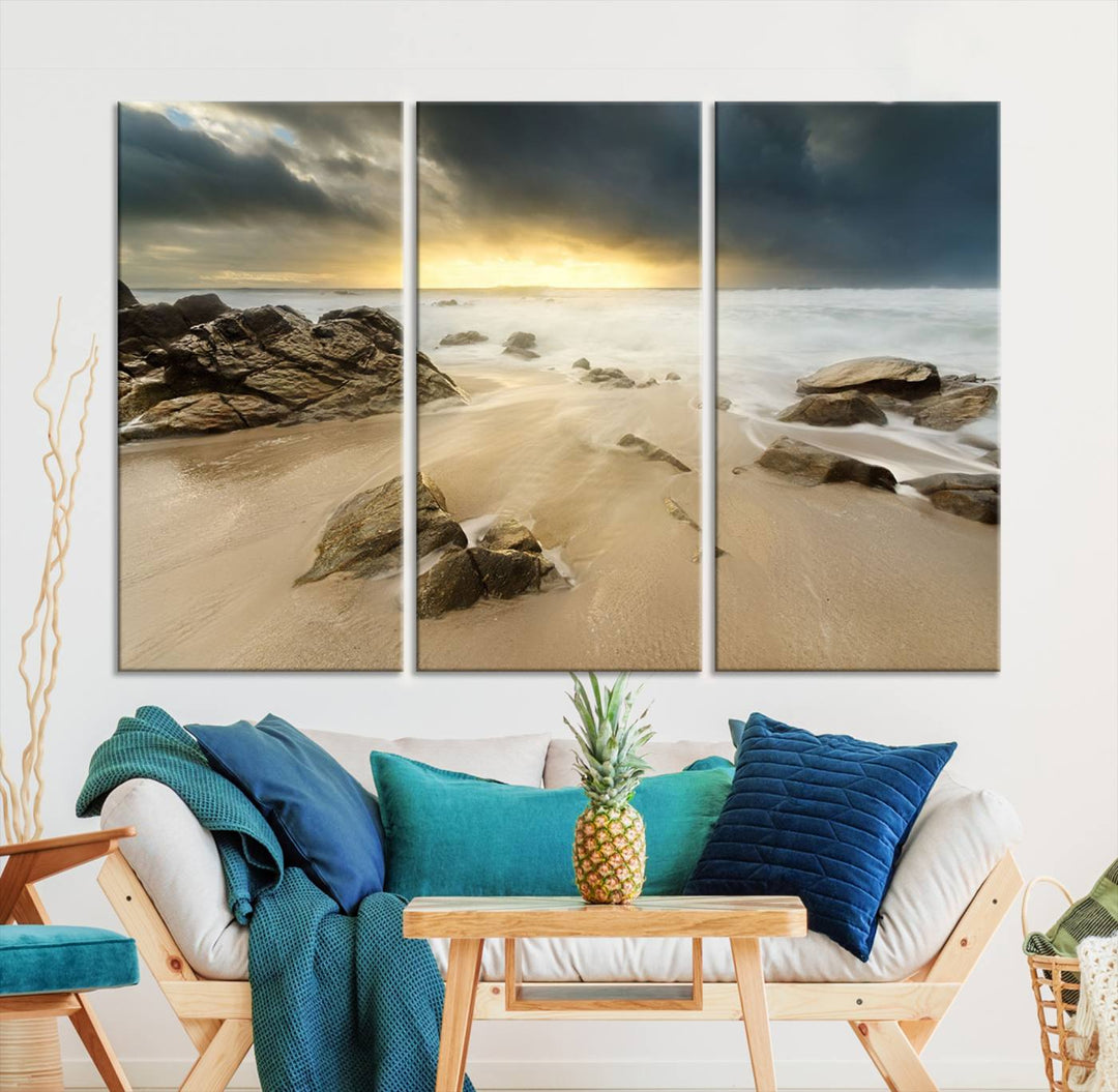 A gallery-wrapped, three-panel artwork titled "Rocks and Waves Wall Art Canvas Print" depicts a rocky beach at sunset. Each canvas showcases museum-quality craftsmanship and a UV-protective coating to maintain its vibrant colors.