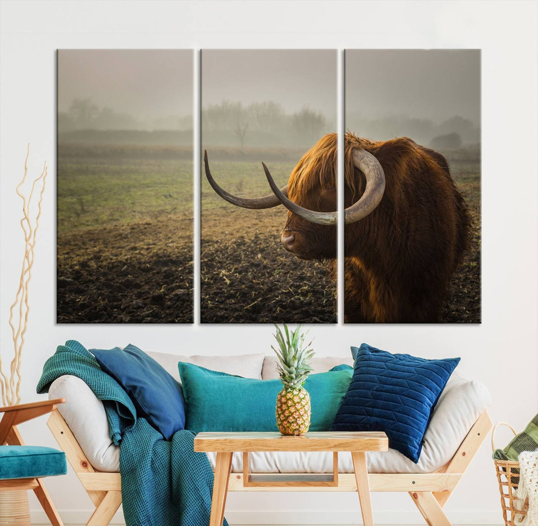 The "Big Cow Horn Wall Art Canvas Print" is a hand-assembled framed canvas depicting a Highland cow in a misty field. It is crafted with a UV-protective coating to ensure lasting vibrancy.