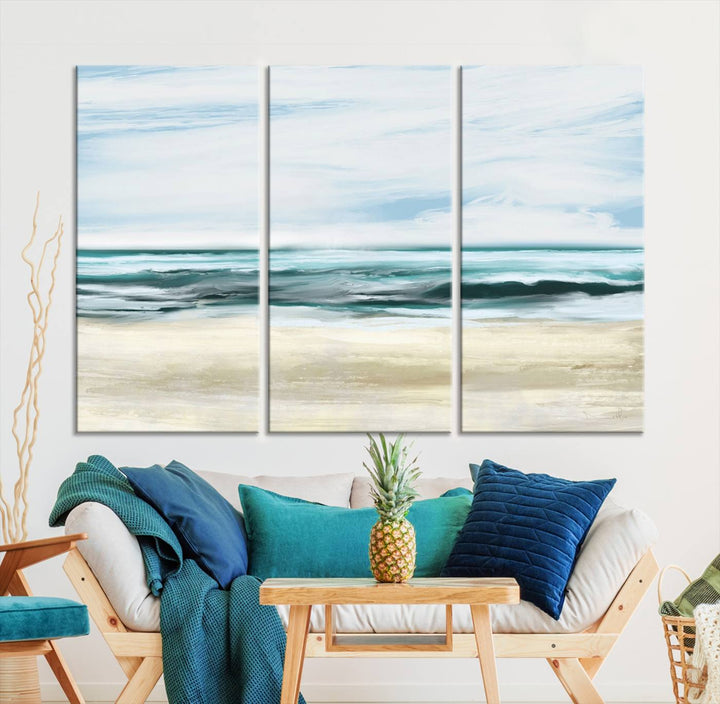 The room features the Ocean Abstract Wall Art Canvas Print, a triptych beach painting on museum-quality canvas with a gallery-wrapped finish and UV-protective coating.