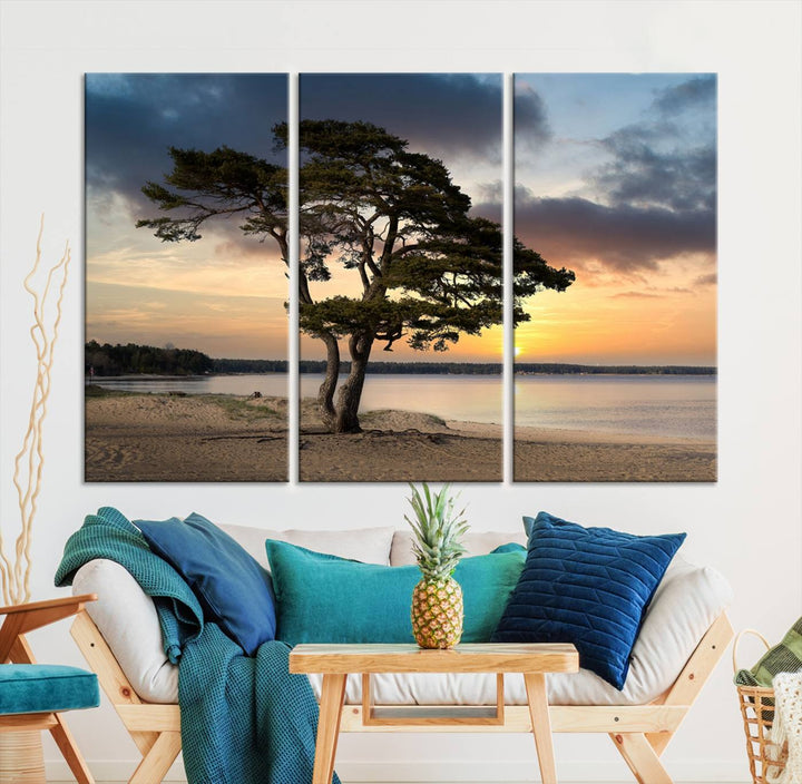 The room showcases the Coastal Sunset Wall Art Canvas Print, a triptych elegantly displayed on museum-quality polycotton canvas, depicting a serene beach sunset with a tree.