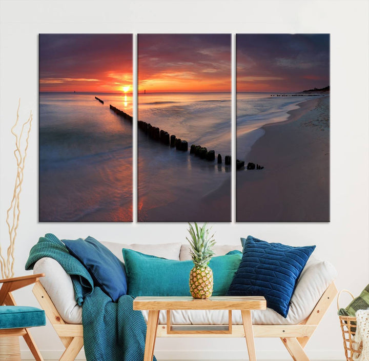 In a modern living room, the Sunset Beach Wall Art Canvas Print is displayed above. This triptych, printed on museum-quality canvas with a UV-protective coating, ensures lasting brilliance. It's ready to hang and brings an elegant touch to your space.