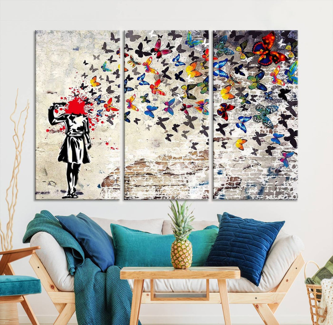 The Banksy Art Butterfly Girl Explosion Canvas showcases a dynamic figure with butterflies bursting from their head, set against a textured wall background. This vibrant urban graffiti piece is perfect for modern interiors and comes ready to hang.