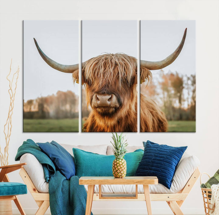 A Highland Cow Animal Scottish Cattle Art Print Farmhouse Wall Art Canvas Print hangs in the living room, adding a touch of rustic farmhouse decor.