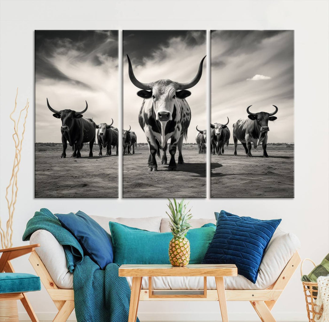 The Black and White Longhorn Cattle Wall Art, featuring a three-panel display of cowboy Western longhorns walking toward the viewer, enhances your space with its striking presence, adding a touch of Western decor.