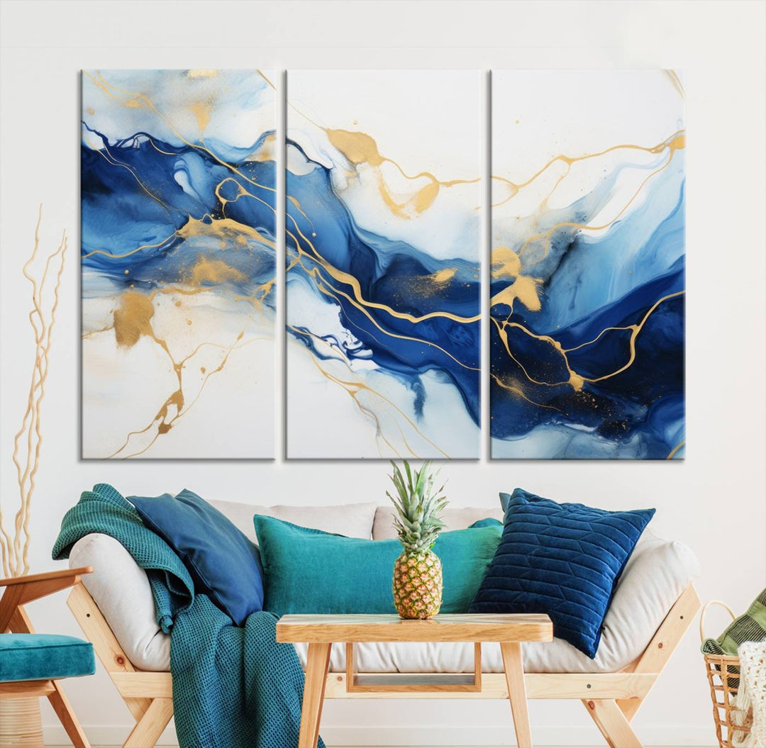 The Blue Abstract Wall Art is displayed as a triptych on museum-quality canvas, showcasing a blue and gold abstract design. The artwork includes a UV-protective coating to maintain its vibrancy and comes with the benefit of free shipping.