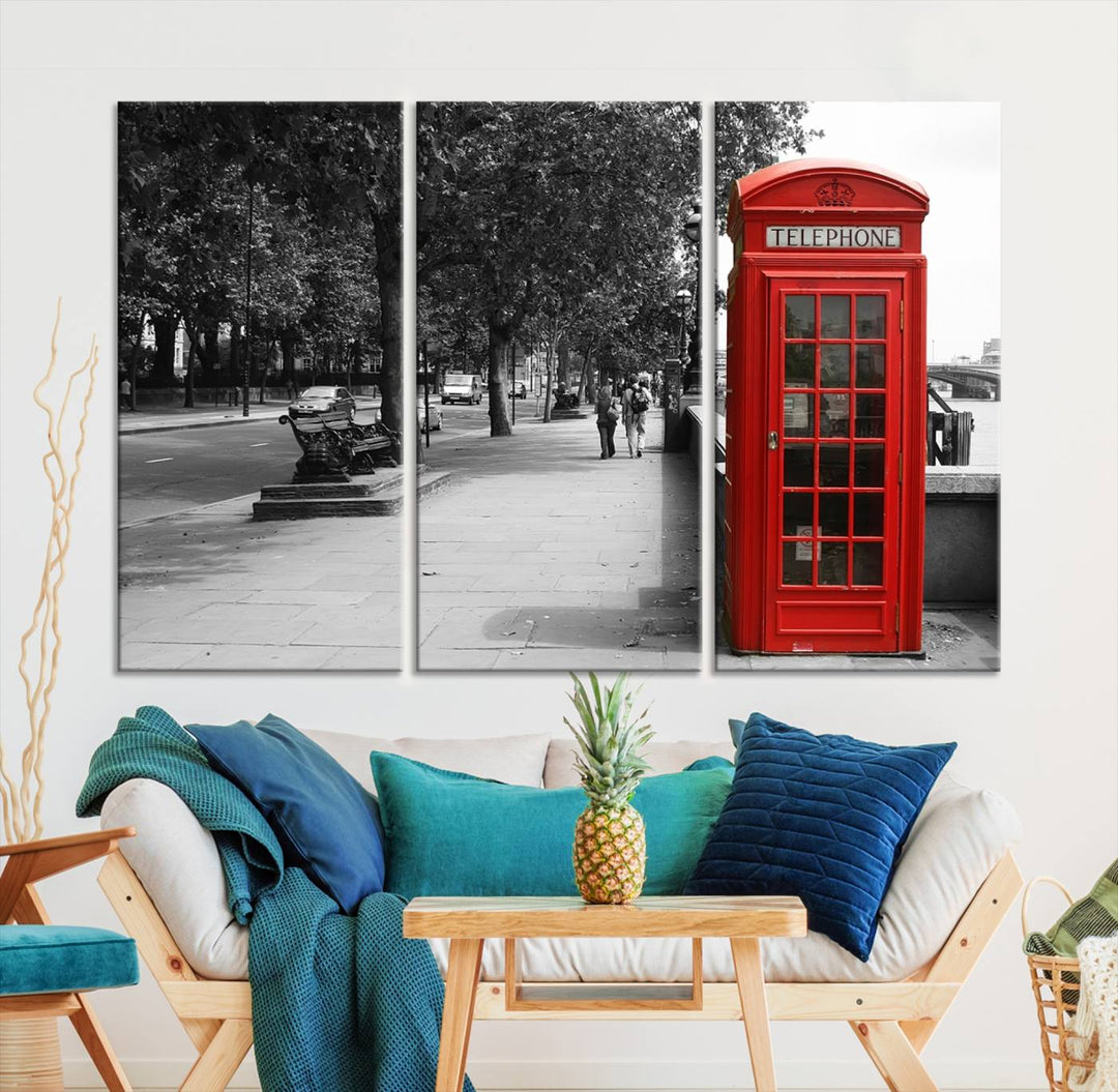 The London Phone Club Wall Art is a stunning piece that showcases a red telephone box set in a black and white street scene on museum-quality canvas. It is gallery wrapped with a UV-protective coating to preserve its vibrant charm.