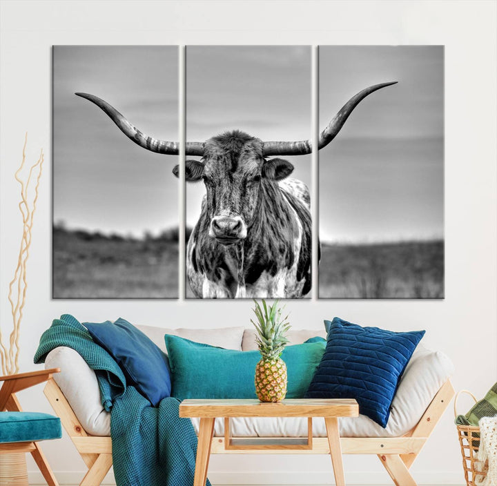 The Texas Longhorn Cow Wall Art, featuring a black and white image of a longhorn bull on canvas, brings charm to the room with its sophisticated appeal.