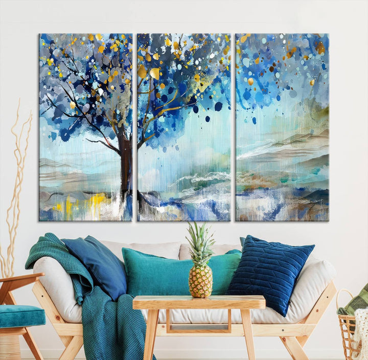 A modern living room features a three-panel Watercolor Style Abstract Tree Printing Wall Art Canvas in vibrant blue and yellow, crafted on museum-quality material.