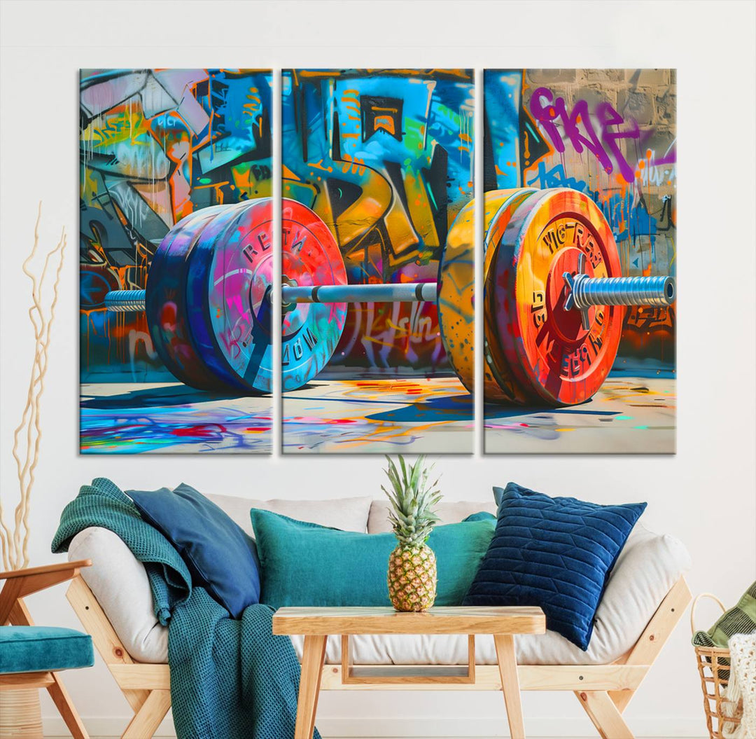 The Fitness Gym Barbell Graffiti Wall Art Canvas Print, a vibrant triptych featuring a barbell against a graffiti backdrop, elegantly hangs in the room. Crafted on premium canvas with a gallery-quality finish, this stunning piece of wall art effortlessly combines urban flair with sophisticated decor.