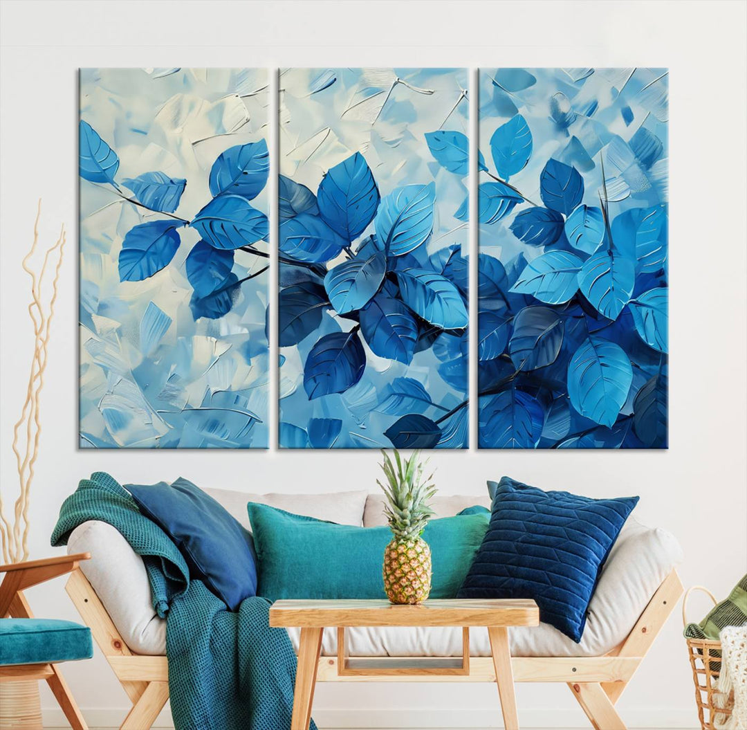 The contemporary living room is highlighted by the Abstract Blue Leaf Wall Art Canvas Print on the wall. The hand-assembled framed art enhances the room's vibrant decor, crafting a gallery-worthy ambience.