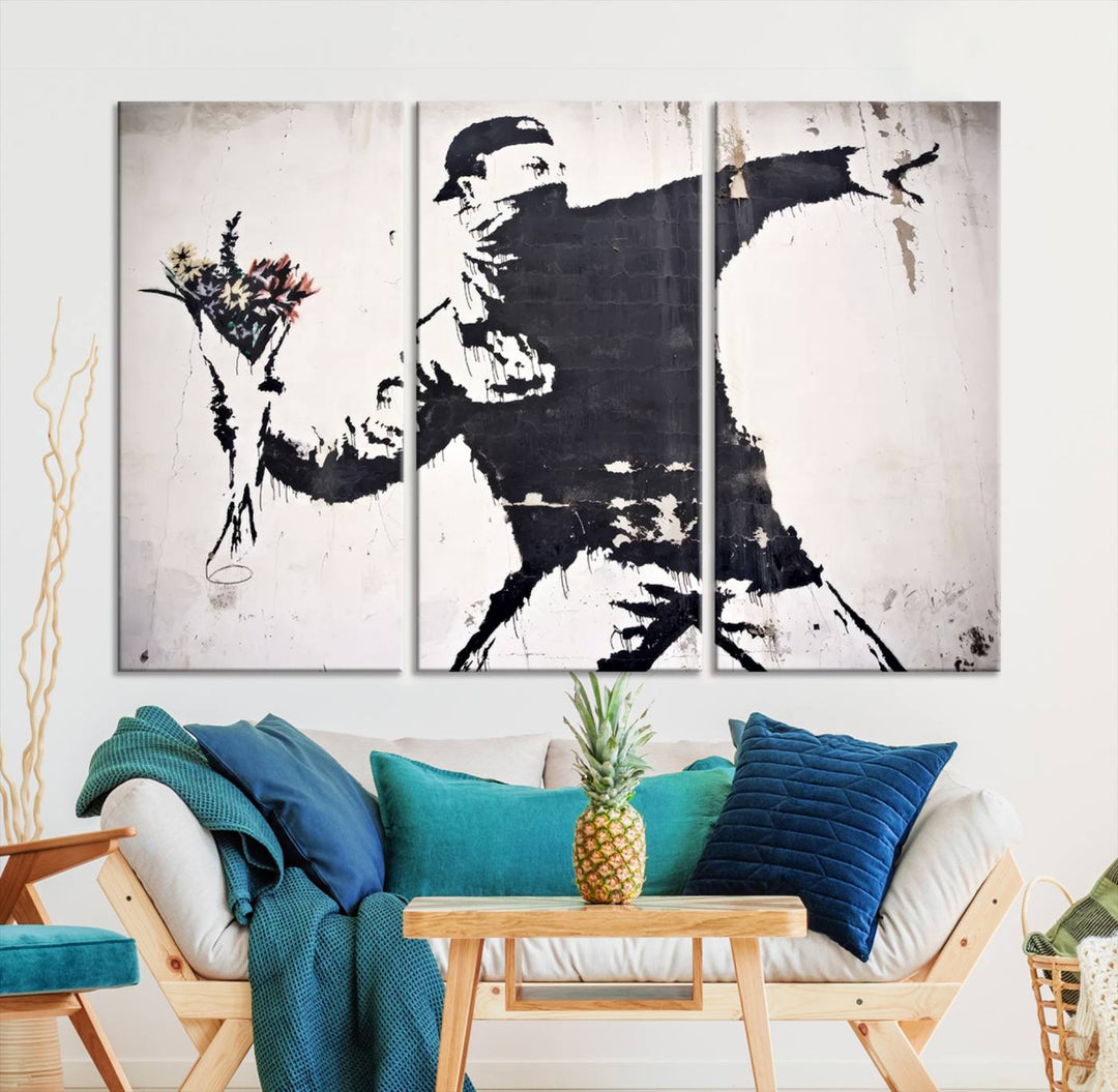 The living room features a split-panel art piece named "Banksy Flower Throw Graffiti Street Wall Art Canvas Print," gallery wrapped on museum-quality polycotton canvas and accentuated by modern decor elements.