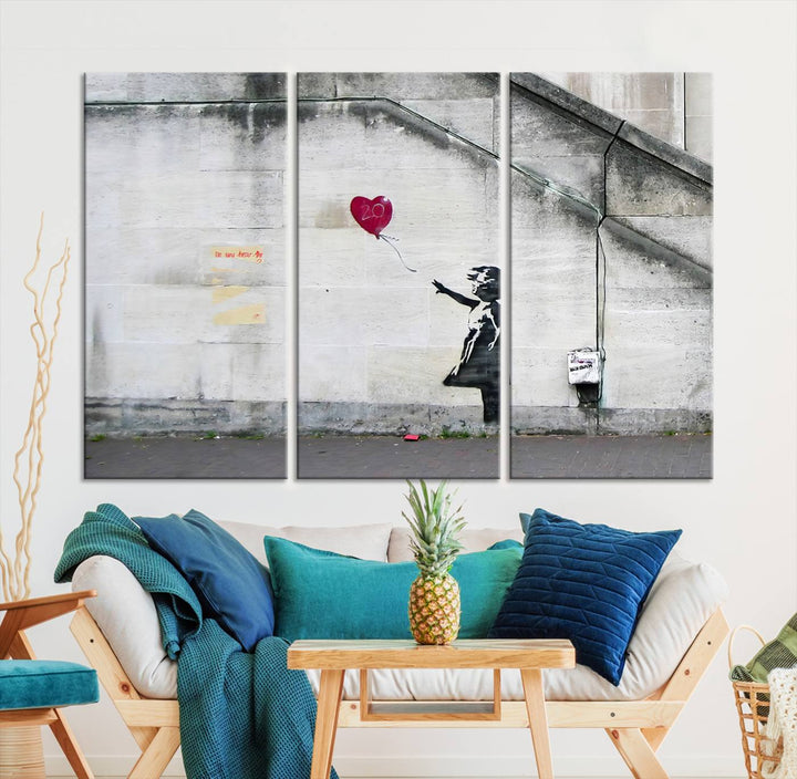 The "Girl with a Balloon Banksy Street Graffiti Art Canvas Print" is a gallery-quality wall art piece that features an image of a girl releasing a heart-shaped balloon. Handmade in the USA, this canvas artwork brings charm and emotion to any room.