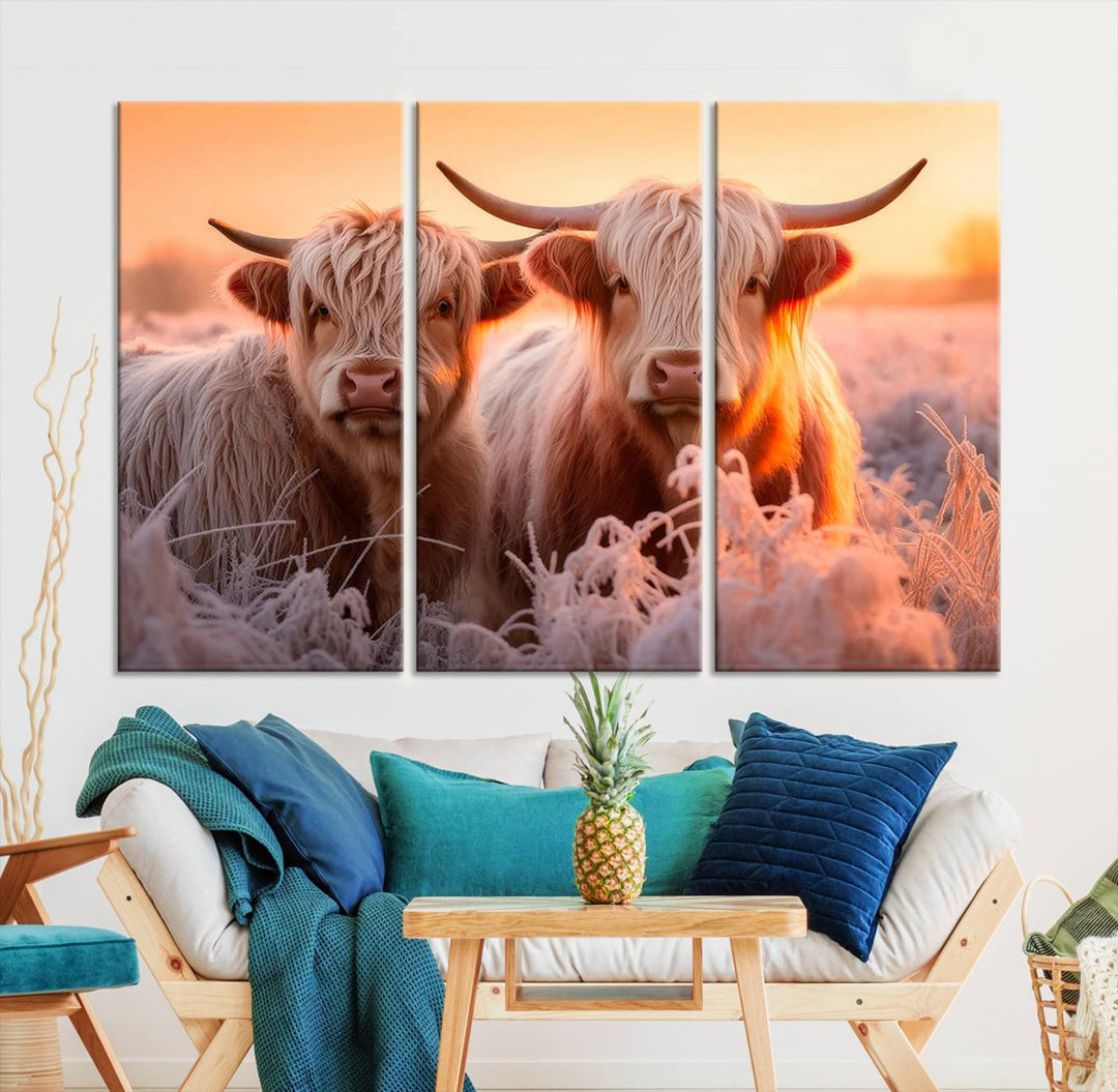 The "Highland Cows at Sunrise Wall Art Canvas Set" beautifully captures a serene and rustic farmhouse aesthetic, portraying two Highland cows in a frosty landscape at sunrise.