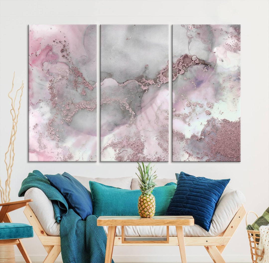 The Rose Marble Abstract Wall Art Canvas Print is a stunning triptych that showcases pink and gray tones, elegantly presented on a dark wall.