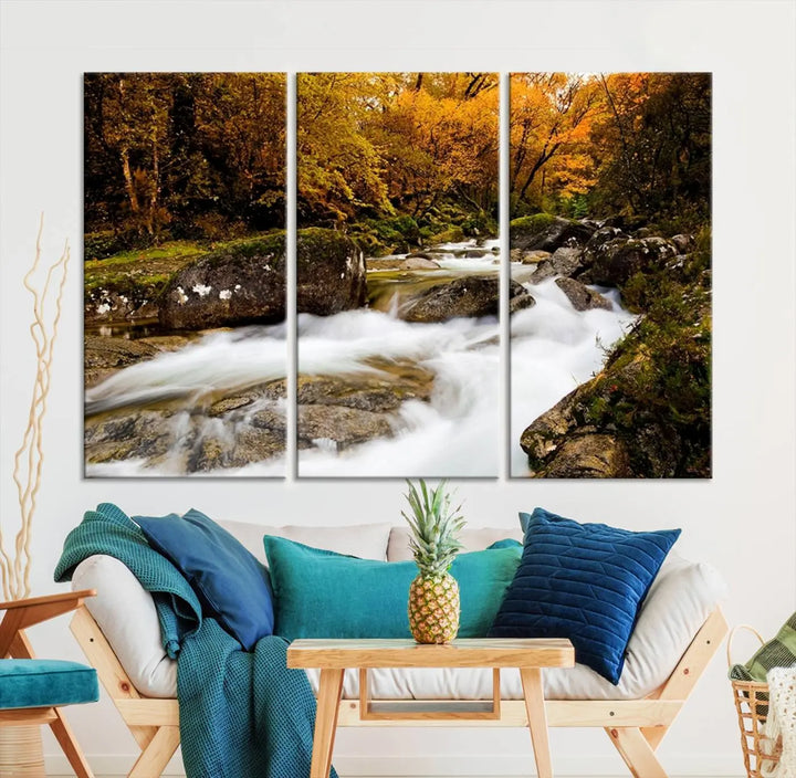 The living room is adorned with the "Wall Art Waterfall Canvas Print River in Forest in Autumn," a triptych on museum-quality canvas showcasing a flowing river surrounded by autumn trees. This ready-to-hang artwork features a UV-protective coating to ensure enduring vibrancy.