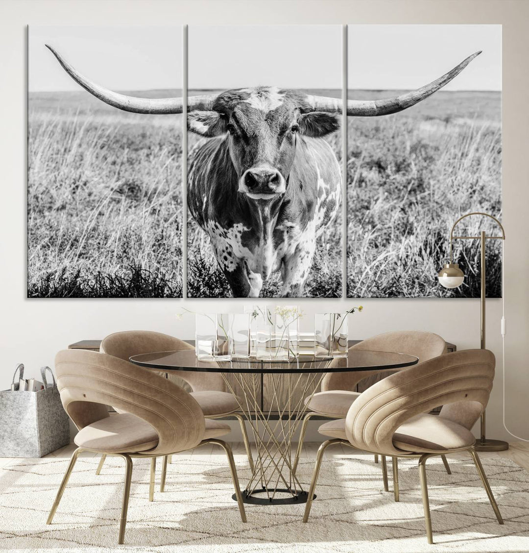 The Texas Cow Longhorn Wall Art Canvas Print is a black and white triptych depicting a cow in a field. It is crafted with museum-quality canvas and features a UV-protective coating.