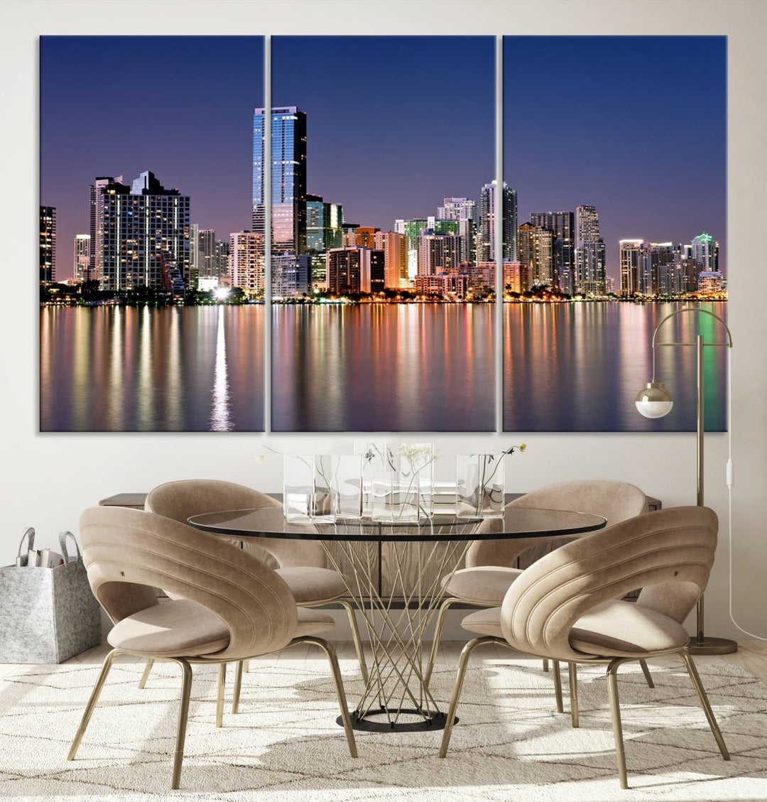 The Miami Skyline Canvas Wall Art Print showcases a vibrant night cityscape and beautifully captures the dazzling colorful lights reflecting on the water. This ready-to-hang triptych adorns the wall, creating a stunning visual centerpiece.