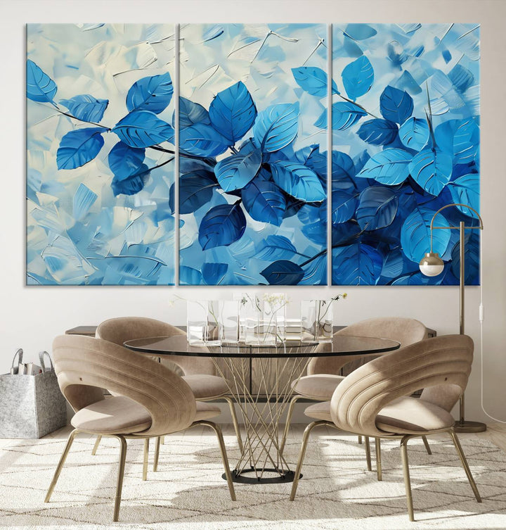 The contemporary living room is highlighted by the Abstract Blue Leaf Wall Art Canvas Print on the wall. The hand-assembled framed art enhances the room's vibrant decor, crafting a gallery-worthy ambience.