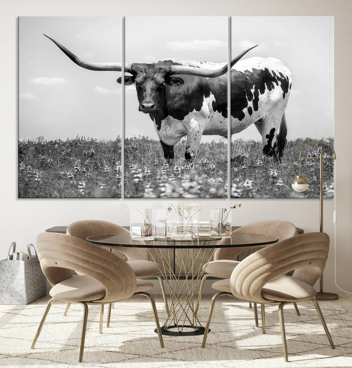 The Texas Black White Highland Longhorn Cow Wall Art Canvas Print, a gallery-quality triptych, elegantly adorns the wall, showcasing a striking black-and-white depiction of a longhorn cow in a field.