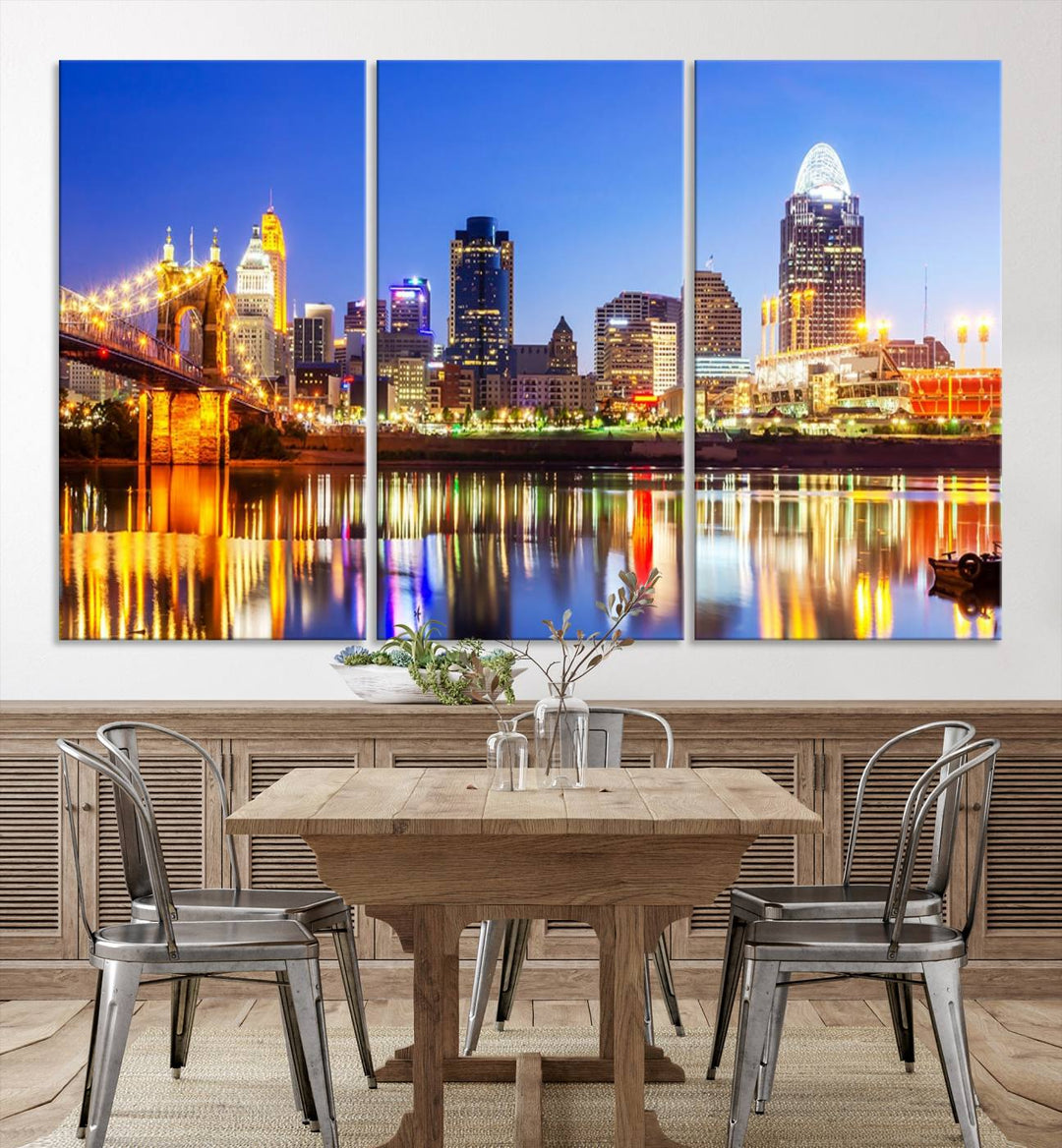 The "Cincinnati City Lights Night Skyline Cityscape View Wall Art Canvas Print" is a gallery-wrapped, museum-quality canvas illustrating a lit-up bridge and skyline at night. Enhanced with a UV-protective coating, this piece ensures lasting vibrancy.