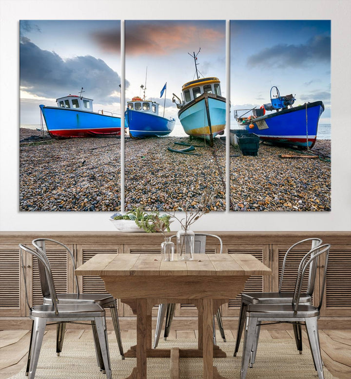 The "Big Boats On The Beach Wall Art Canvas Print" is a stunning piece featuring three museum-quality panels depicting fishing boats on a pebbled shore. Ready to hang and featuring UV-protective coating, it serves as an elegant addition to your home décor.