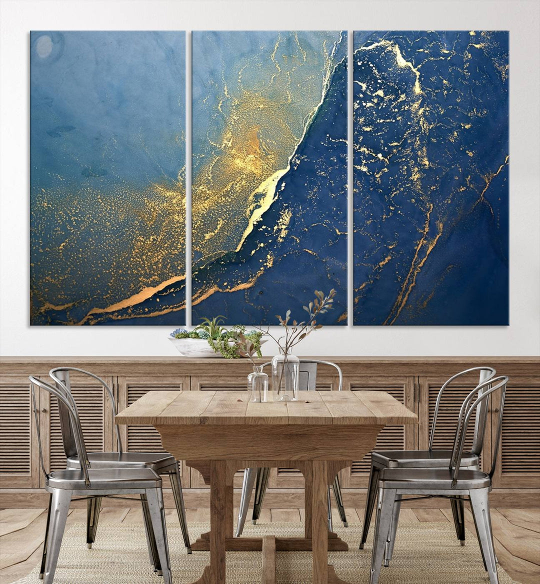 The Navy Blue Yellow Twinkle Wall Art Canvas Print, featuring an abstract design in gold and blue, enhances a modern living room as it adorns a white wall with its gallery-wrapped, museum-quality canvases for an exquisite touch.