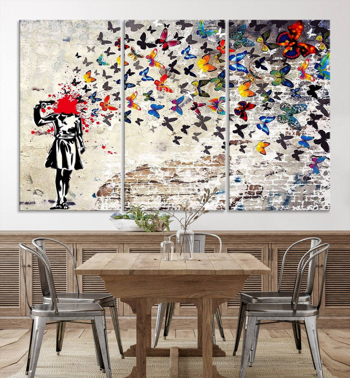 The Banksy Art Butterfly Girl Explosion Canvas showcases a dynamic figure with butterflies bursting from their head, set against a textured wall background. This vibrant urban graffiti piece is perfect for modern interiors and comes ready to hang.