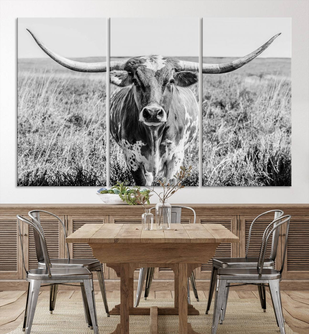 The Texas Cow Longhorn Wall Art Canvas Print is a black and white triptych depicting a cow in a field. It is crafted with museum-quality canvas and features a UV-protective coating.