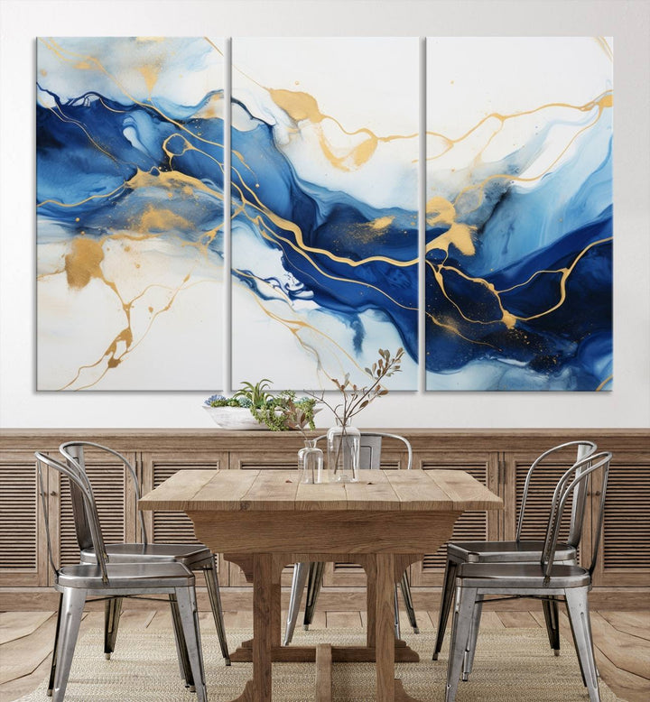 The Blue Abstract Wall Art is displayed as a triptych on museum-quality canvas, showcasing a blue and gold abstract design. The artwork includes a UV-protective coating to maintain its vibrancy and comes with the benefit of free shipping.