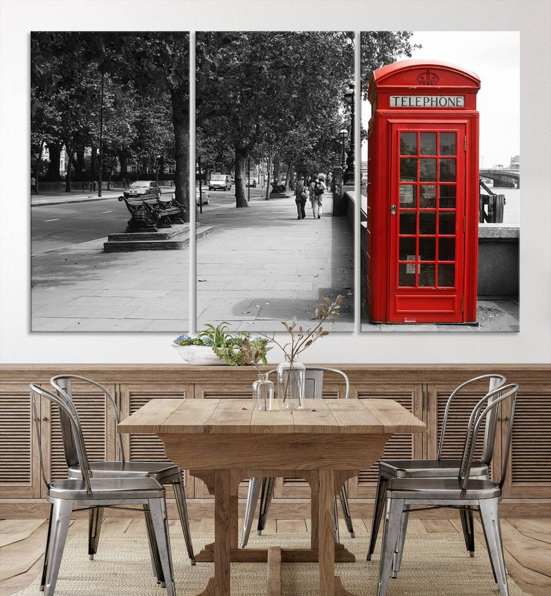 The London Phone Club Wall Art is a stunning piece that showcases a red telephone box set in a black and white street scene on museum-quality canvas. It is gallery wrapped with a UV-protective coating to preserve its vibrant charm.