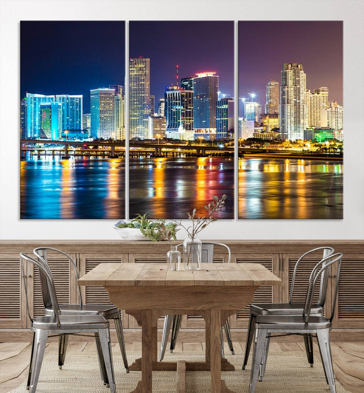 The Wall Art MIAMI Canvas Print features a stunning triptych of a city skyline at night, with vibrant lights reflecting on the water. This gallery-wrapped piece on museum-quality canvas delivers an exquisite finish.