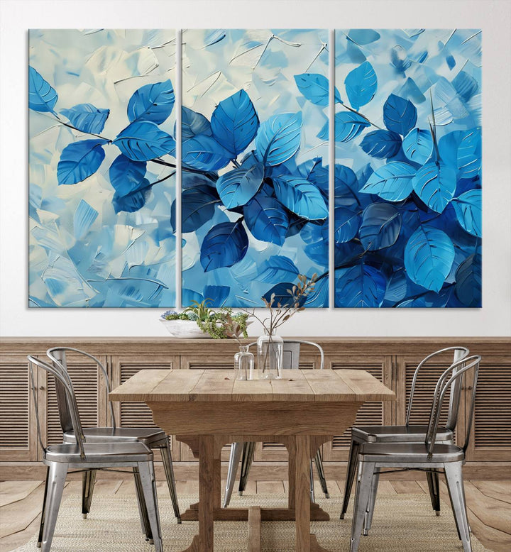 The contemporary living room is highlighted by the Abstract Blue Leaf Wall Art Canvas Print on the wall. The hand-assembled framed art enhances the room's vibrant decor, crafting a gallery-worthy ambience.