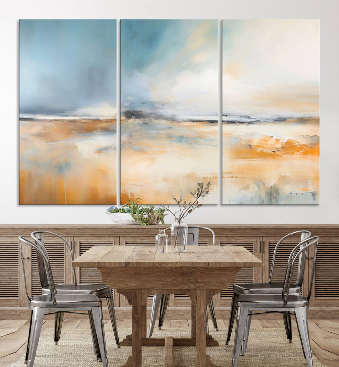 The Abstract Landscape Wall Art Canvas Print, featuring warm tones of orange and blue, is displayed on a dark wall.