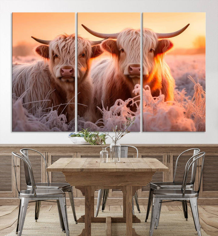 The "Highland Cows at Sunrise Wall Art Canvas Set" beautifully captures a serene and rustic farmhouse aesthetic, portraying two Highland cows in a frosty landscape at sunrise.