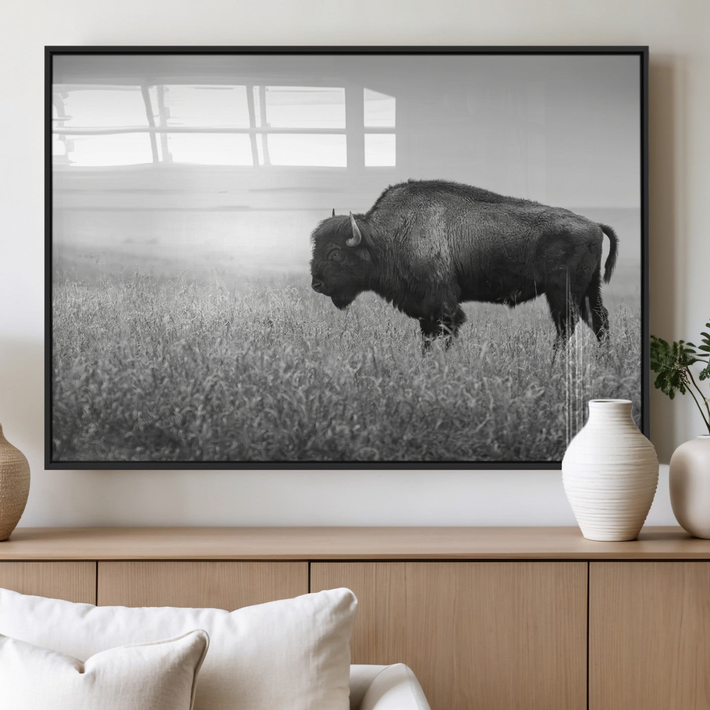 A black and white photograph of a majestic bison standing in a vast grassy prairie, evoking a sense of wilderness and strength.