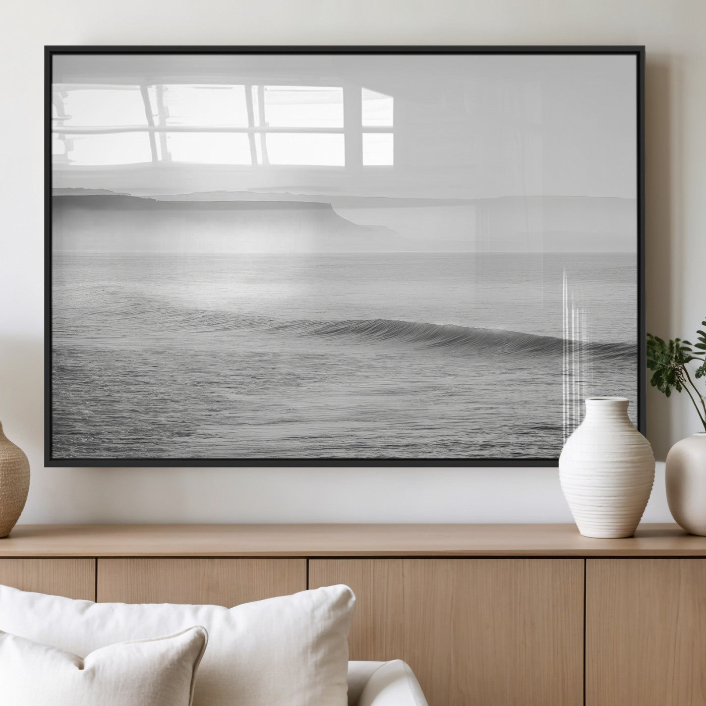 A black and white minimalist seascape featuring soft rolling waves and misty distant cliffs, creating a serene and timeless coastal atmosphere.