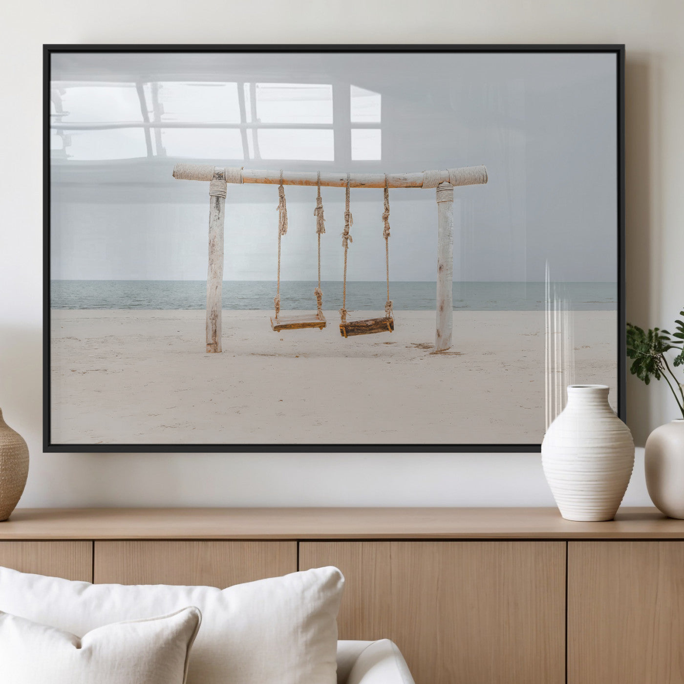 A rustic wooden beach swing stands on a serene sandy shore with an ocean horizon in the background, creating a tranquil and dreamy coastal escape.