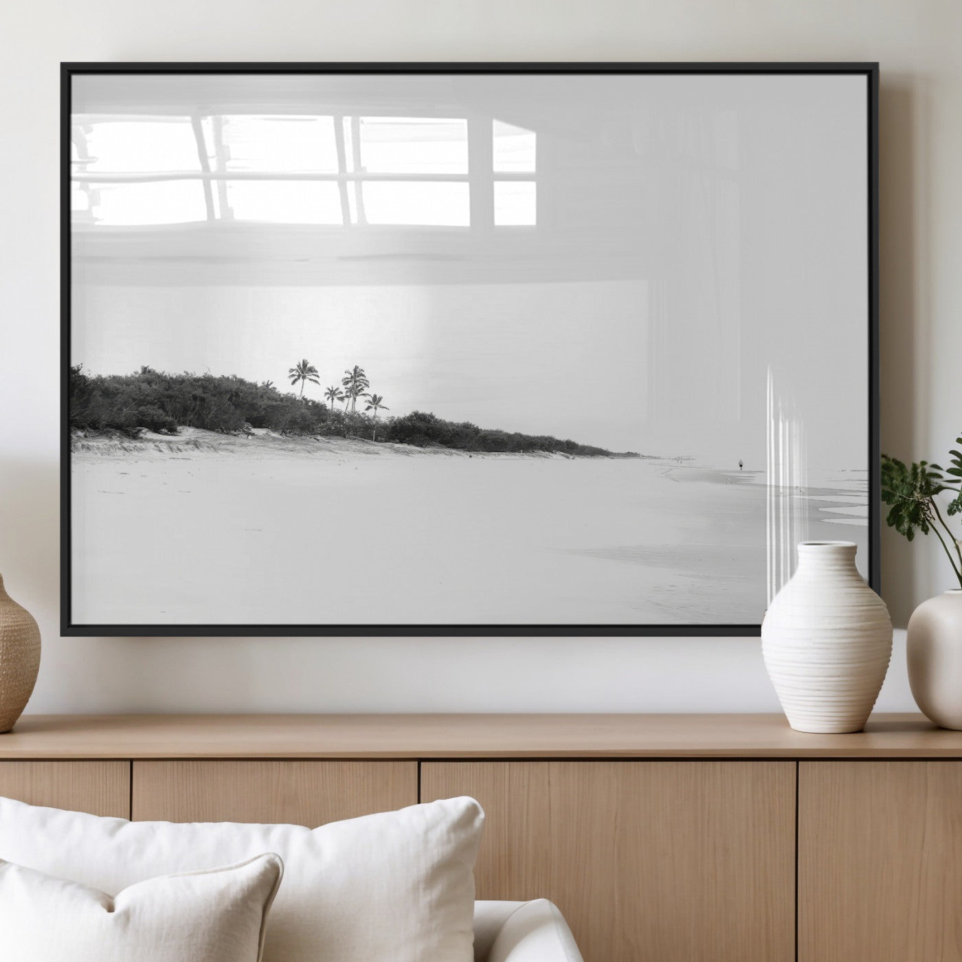 A black and white minimalist coastal scene with a vast open beach, distant palm trees, and a lone figure walking along the shoreline, evoking serenity and solitude.