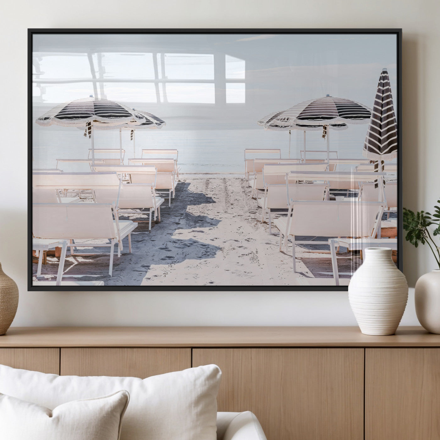A serene minimalist beach scene featuring striped umbrellas, soft pastel sand, and an elegant lounge setup, creating a tranquil and stylish coastal retreat.